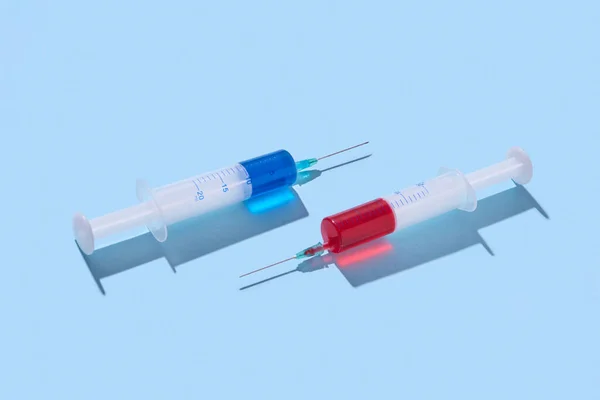 Zwei Chirurgische Einmalspritzen Mit Rotem Und Blauem Serum Oder Impfstoff — Stockfoto