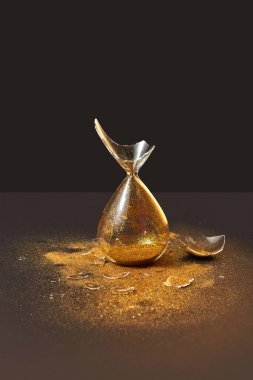 Eski moda dikey dikey ayakta dikey cam kırıkları ve duoton koyu bir zemin üzerinde altın kum parçacıkları, kopyalama uzayı.