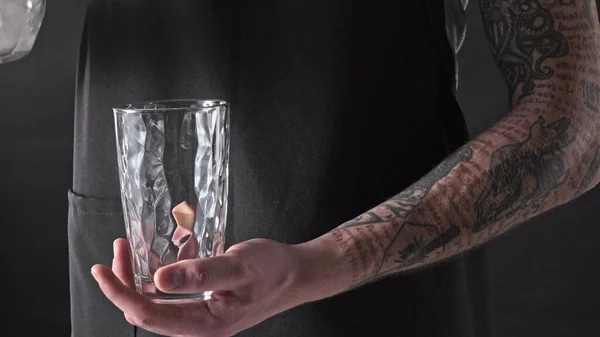 바리스타 남자가 어두운 얼음을 방울떨어뜨리는 물컵에 붓는다 Uhd 비디오 240Fps — 스톡 사진