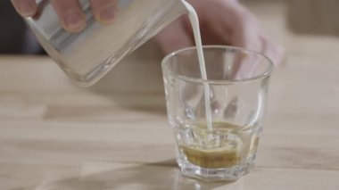 Sütlü kahve. Süt bir bardak kahveye dökülür..