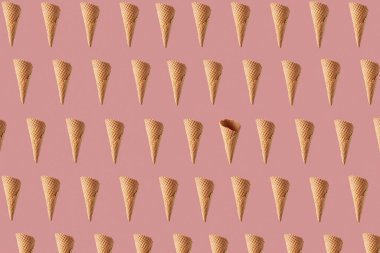 Tatlı dondurma yapmak için yüzen gevrek waffle külahlarından gelen yatay yemek kalıpları ya da şeftali pembesi arkaplanına karşı tatlılar.