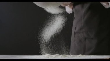 Kadın elleri masada un hazırlıyor, hamur yoğuruyor.