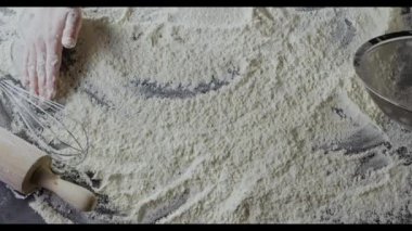 Kadın elleri masada un hazırlıyor, hamur yoğuruyor.