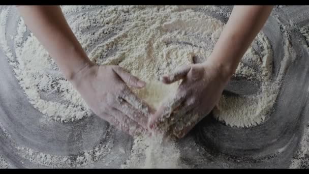mains féminines préparant la farine sur la table, pétrissant la pâte 