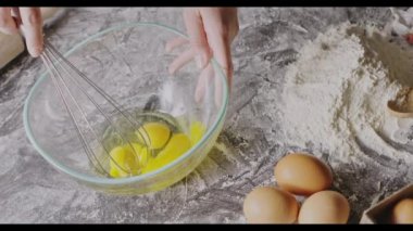 Kadın çırpılmış yumurta sarısı çırpıyor, hamur yoğurmaya hazırlanıyor.