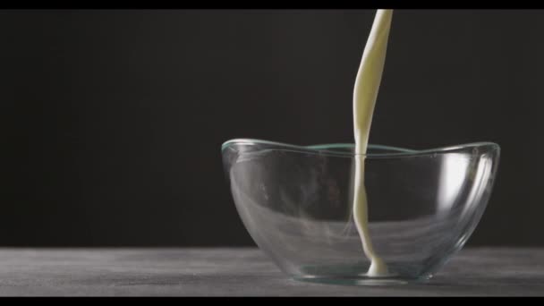 Mjölk Hälls Glasskål Mörk Bakgrund Slow Motion — Stockvideo