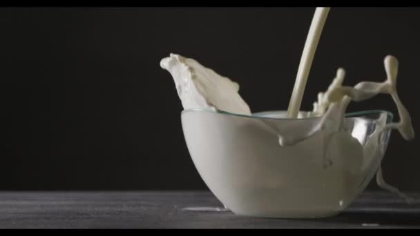 Mjölk Hälls Glasskål Mörk Bakgrund Slow Motion — Stockvideo