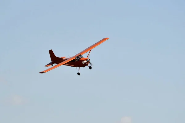Nel cielo il piccolo aereo arancione vola . — Foto Stock