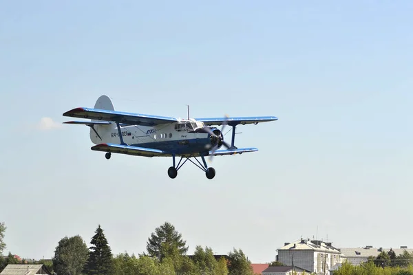 Over the city the An-2 Plane belonging to UTair airline flies. 8 — Stock Photo, Image