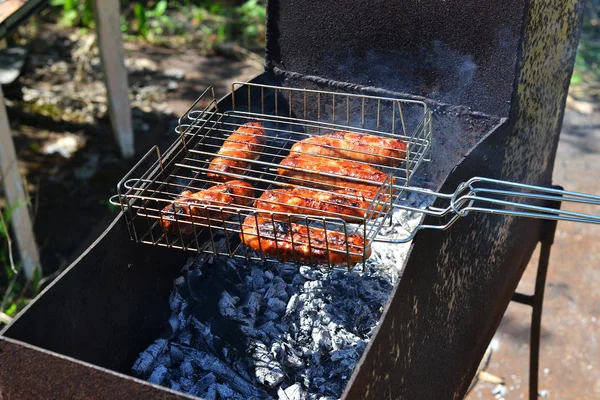 Würstchen vom Grill werden auf einem Kohlenbecken gebraten. — Stockfoto