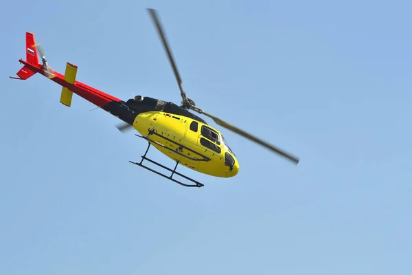 El pequeño helicóptero amarillo vuela en el cielo . — Foto de Stock