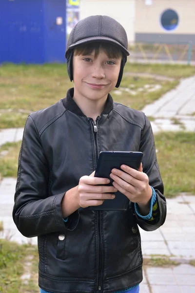 O retrato do adolescente com o computador tablet nas mãos — Fotografia de Stock