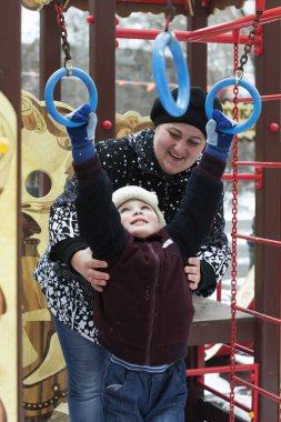Mutlu küçük çocuk oyun alanında anne ile oynar 