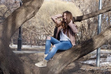 Güzel Rus kız uzun saçlı bir ağaç ve SMI oturur