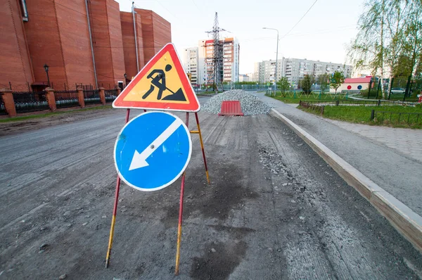 Road repairs, road signs and a bunch of crushed stone on the road.