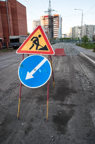 Road repairs, road signs and a bunch of crushed stone on the road.