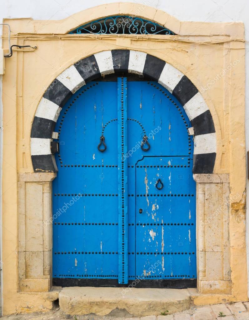 Puerta azul tradicional con arco 2024