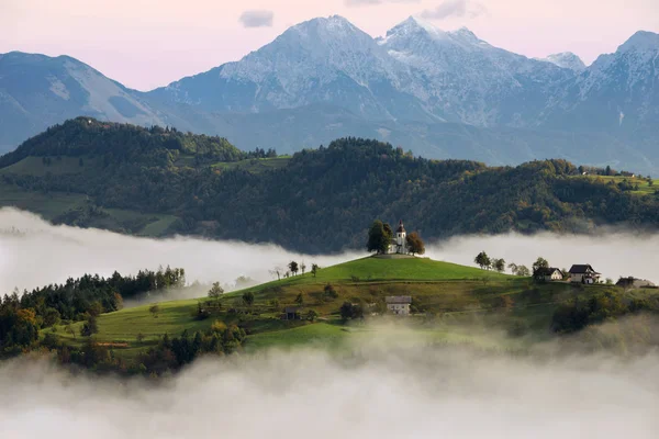 Αγίου Θωμά εκκλησία βουνών της Σλοβενίας σε μια ομιχλώδη Ανατολή — Φωτογραφία Αρχείου
