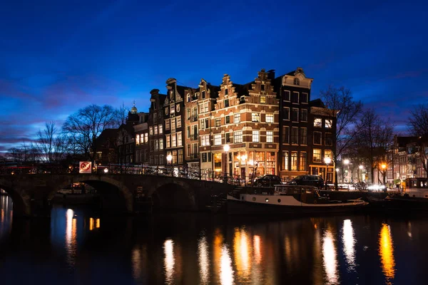Amsterdam canal houses illuminated at dusk — Stock Photo, Image