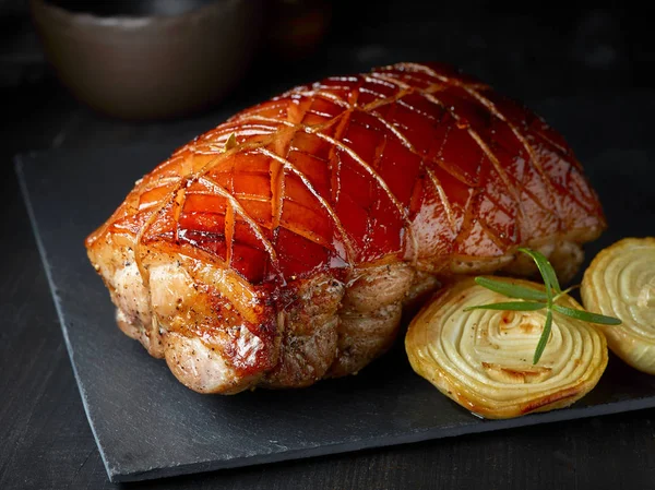 Roasted pork on black stone plate — Stock Photo, Image