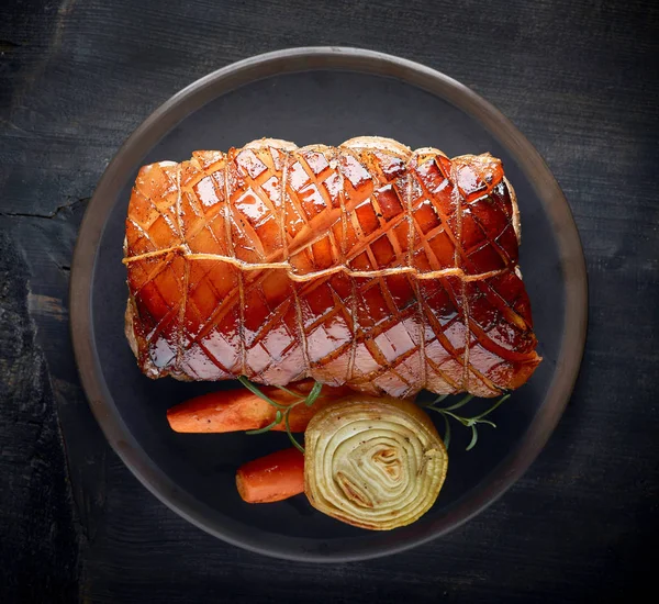 Roasted pork on dark plate — Stock Photo, Image