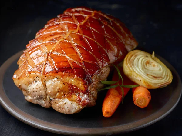 Roasted pork on dark plate — Stock Photo, Image