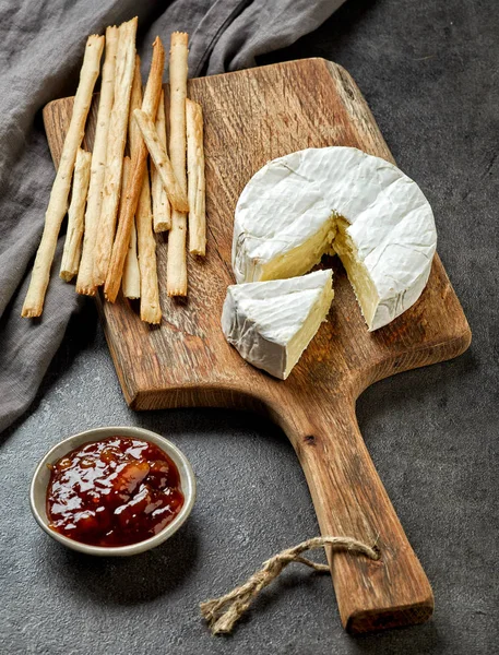 Queijo camembert na placa de corte de madeira — Fotografia de Stock