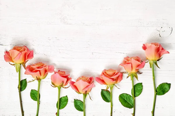 Rosas cor-de-rosa na mesa de madeira branca — Fotografia de Stock