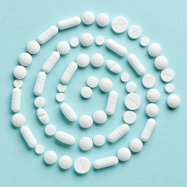 Tabletki leku biały na niebieskim tle — Zdjęcie stockowe