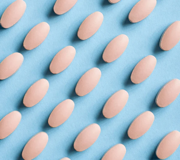 Pink pills on blue background — Stock Photo, Image