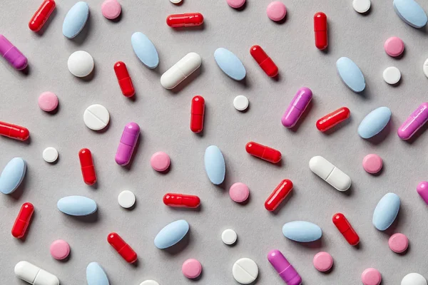 Pillole colorate su sfondo grigio — Foto Stock