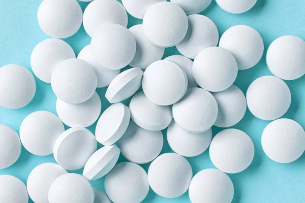 Белые таблетки на синем фоне — стоковое фото