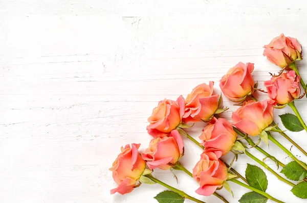 Rosas rosadas sobre fondo de madera blanca — Foto de Stock