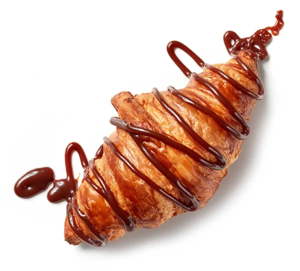 Freshly baked croissant decorated with chocolate sauce — Stock Photo, Image