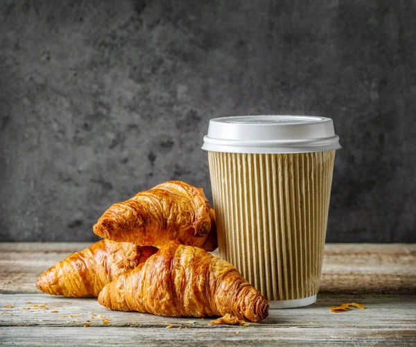 Tasse Kaffee und frisch gebackene Croissants — Stockfoto