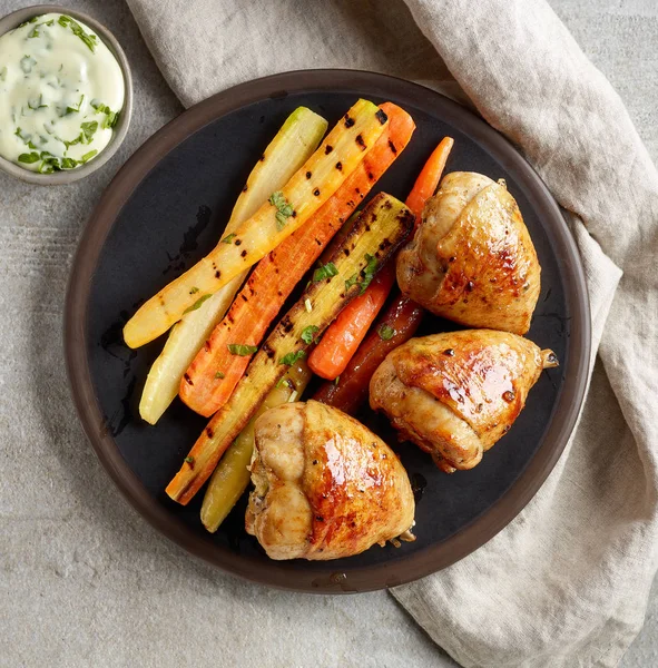 Piatto di cosce di pollo alla griglia e carote — Foto Stock