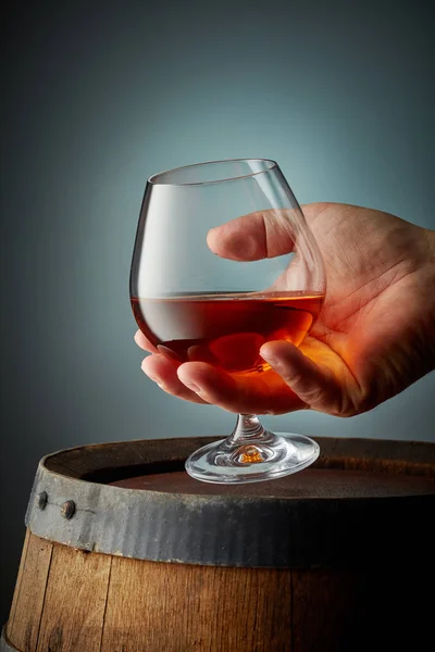 Glas cognac in de menselijke hand — Stockfoto