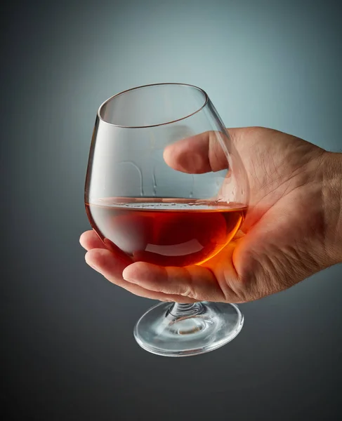 Verre de cognac à la main humaine — Photo