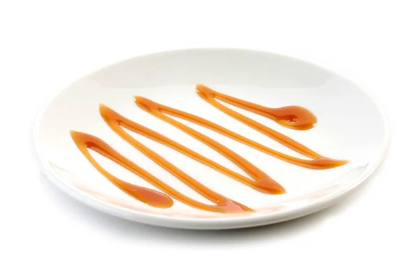 Karamellsoße auf weißem Teller — Stockfoto