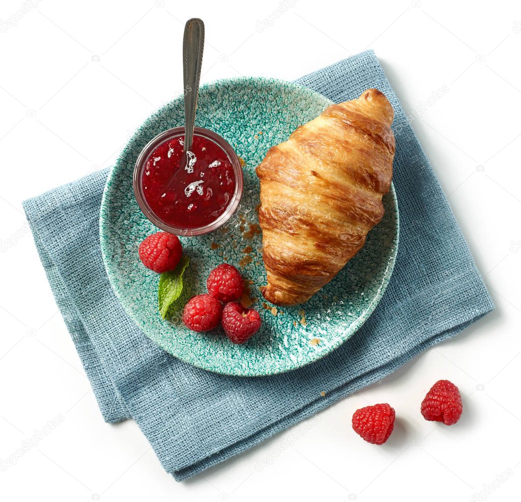 freshly baked croissant and jam on blue plate isolated on white background, top view