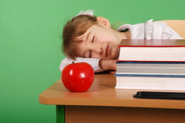 Menina em uniforme escolar dormindo em sua mesa — Fotografia de Stock