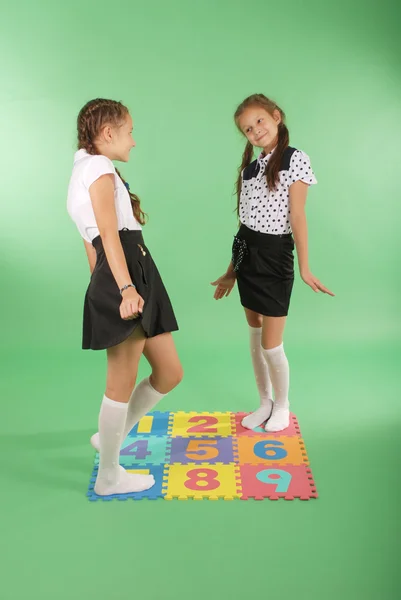 Two girls on rug with numbers — Stock Photo, Image