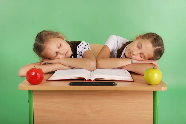 Twee meisjes van school slapen op een stapel boeken op haar Bureau — Stockfoto