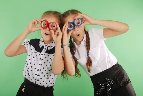 Дві красиві школярки тримають дві ізолюючі стрічки на очах — стокове фото