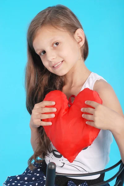 Retrato de uma jovem com um coração nas mãos — Fotografia de Stock