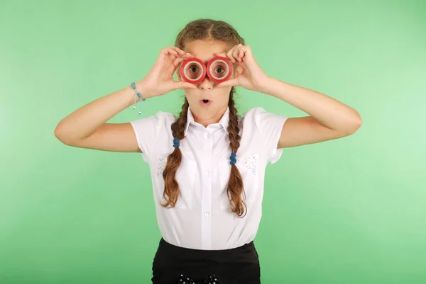 Beautiful school girl holding two insulating tape on eyes — Stock Photo, Image