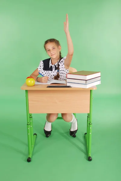Девушка в школьной форме поднимает руку, чтобы задать вопрос — стоковое фото