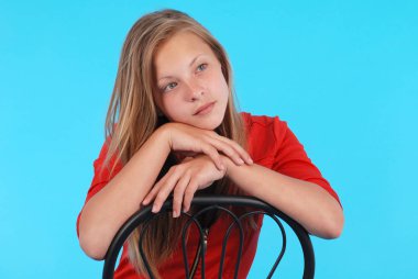 Gülümseyen kız izole bir sandalyede oturuyor