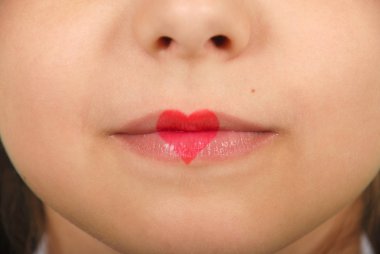 Genç güzel kız dudaklarından çizim kalp ile oynarken