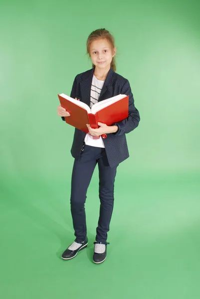 Jovem menina da escola com livro vermelho — Fotografia de Stock